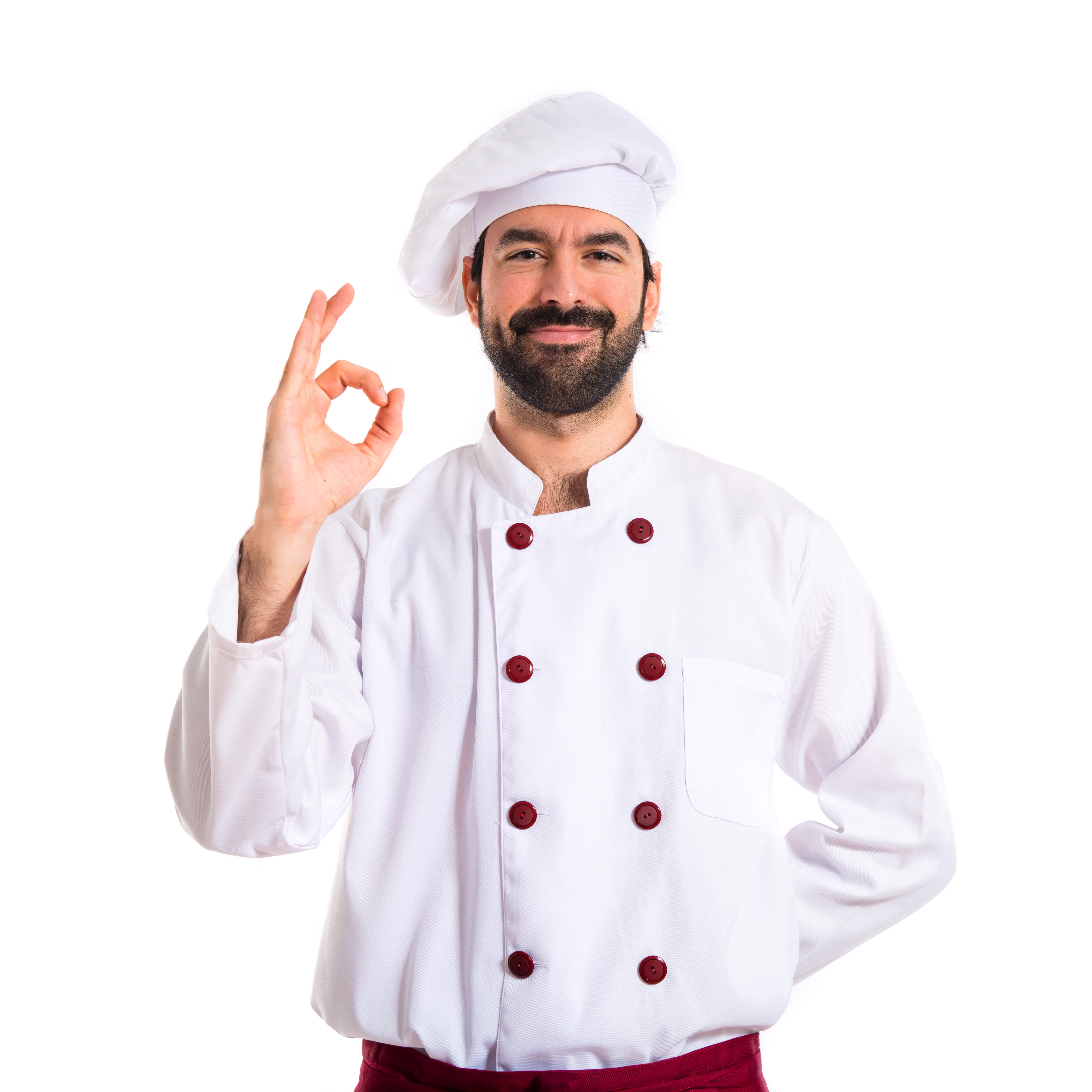 a chef wearing a white chef outfit with red strips and a red apron and smiling